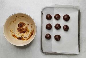 rolled out ginger molasses cookie dough bites on baking sheet lined with parchment paper