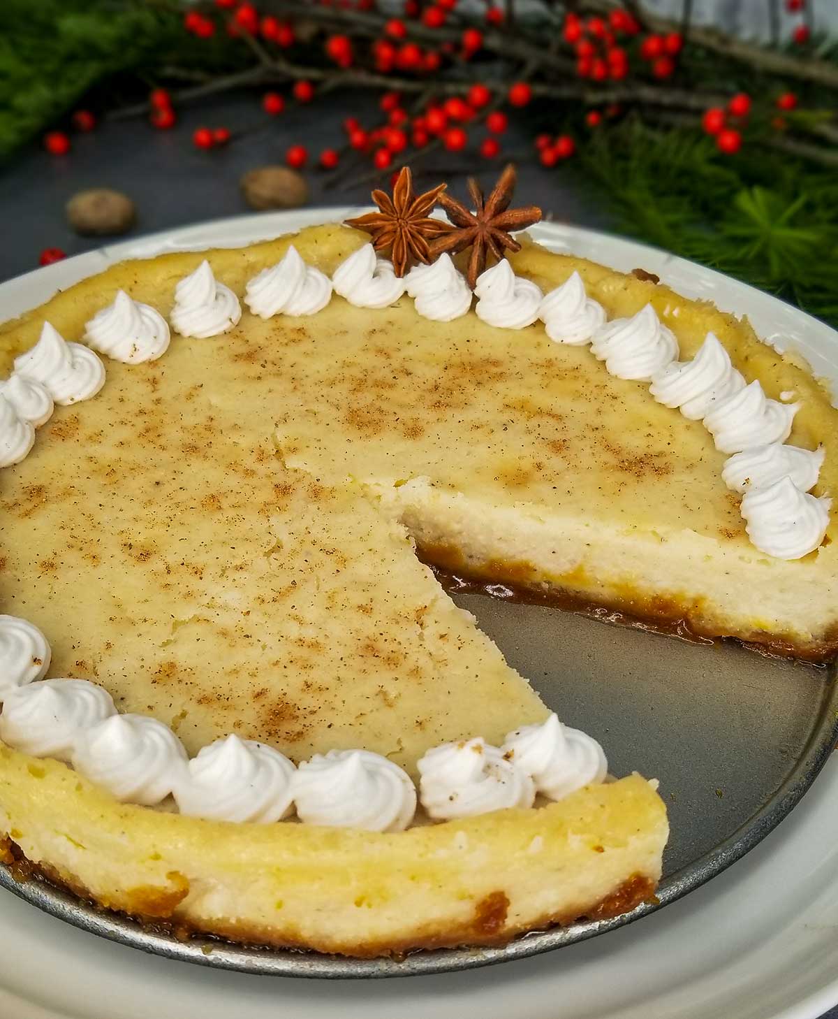 side view of cheesecake with one piece missing and coconut whipped cream lining the edges