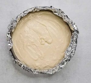 cheesecake filling poured into spring form pan on top of cooled crust