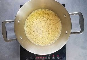 picture of eggnog and other ingredients just at a boil in large pot
