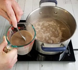 adding potato flour slurry to soup