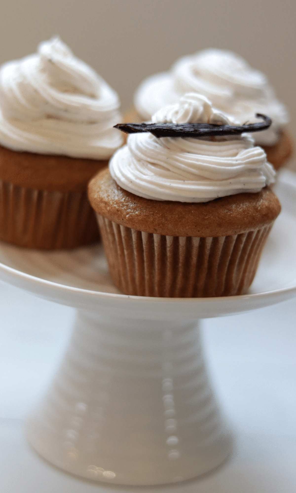 vanilla bean cupcakes on white cake stand