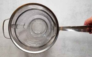 Large glass measuring dish with large strainer on top