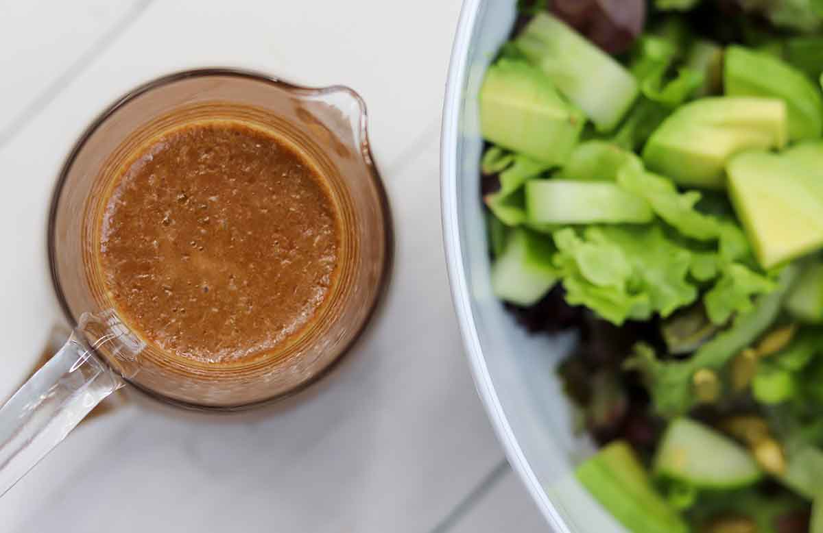 Overhead view of maple balsamic dressing beside bowl of salad