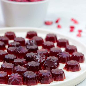 Pomegranate gelatin Gummies with pomegranate seeds behind