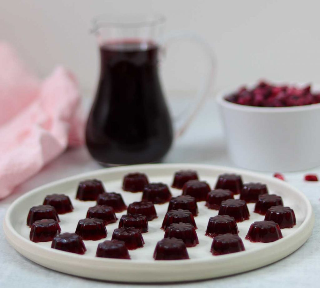 Gummies with pomegranate juice in background
