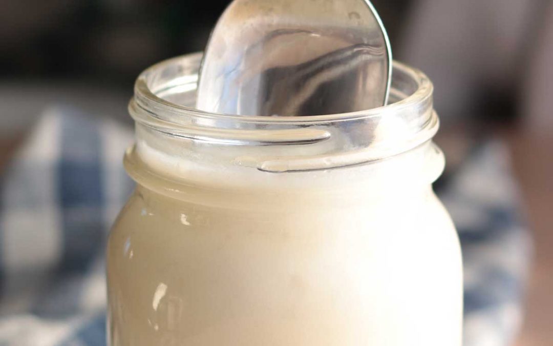 Beef tallow sitting in a mason jar with a spoon