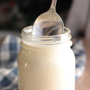 Beef tallow sitting in a mason jar with a spoon