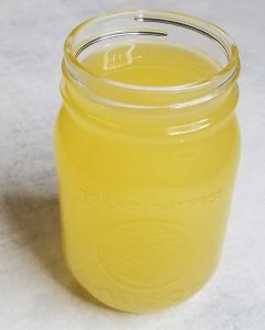 Golden colored liquid lard in a mason jar