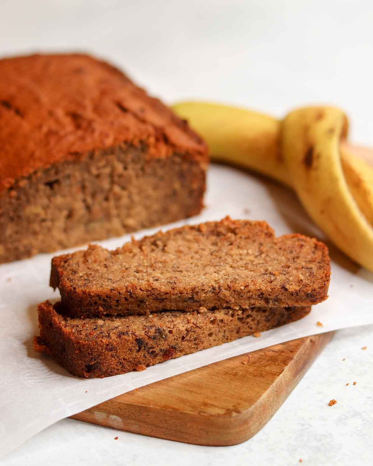 two pieces of banana bread on a cutting board stacked on top of each other