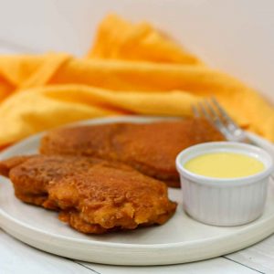 side view of chicken on plate with sauce