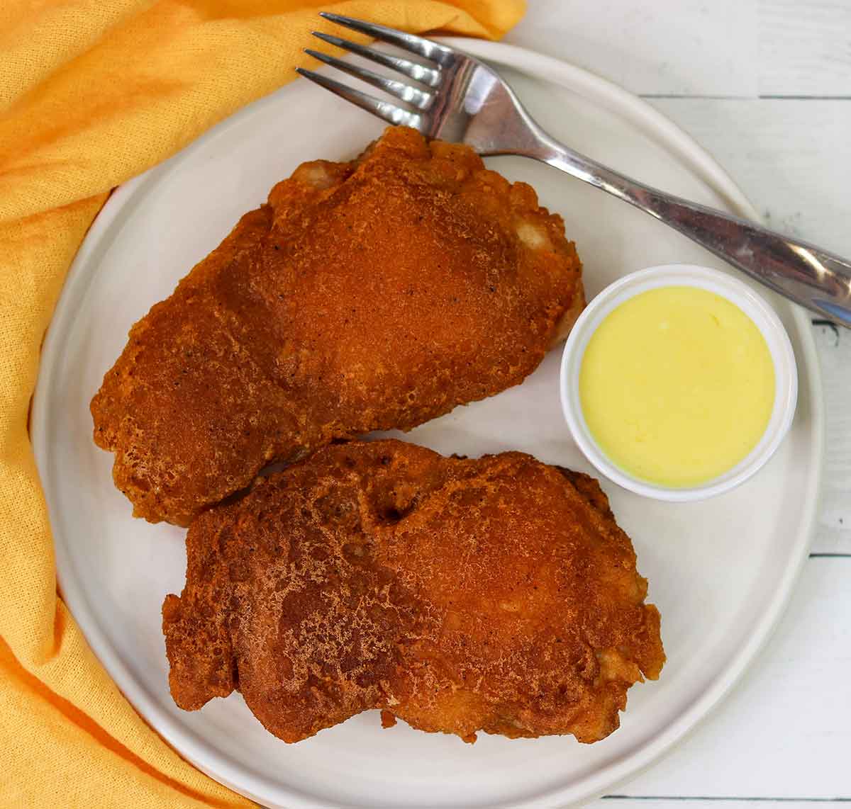 over head view of fried chicken on plate with sauce