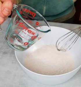 pouring club soda into dry ingredients for batter