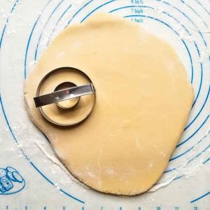 Doughnut cutter pressing into rolled out dough