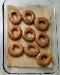 Doughnuts after their first dip in maple glaze