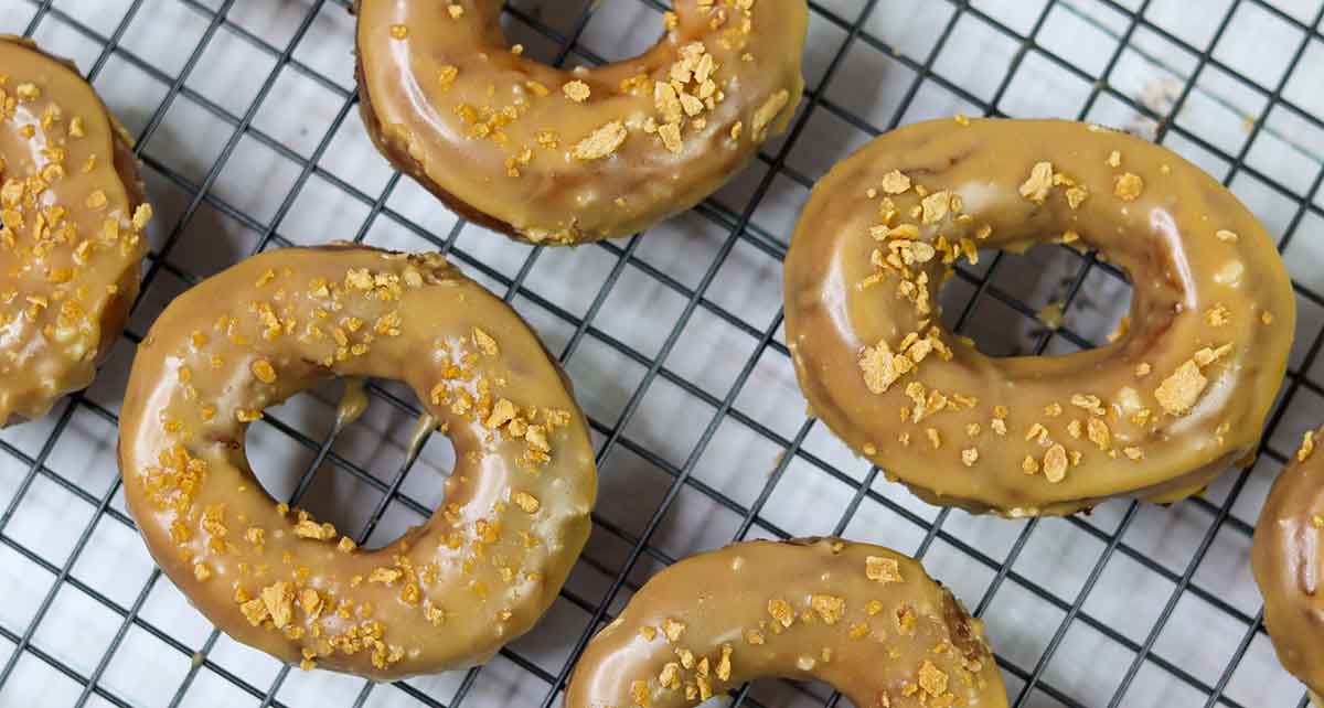 Top-down view of glazed doughnuts cooling on a cooling rack