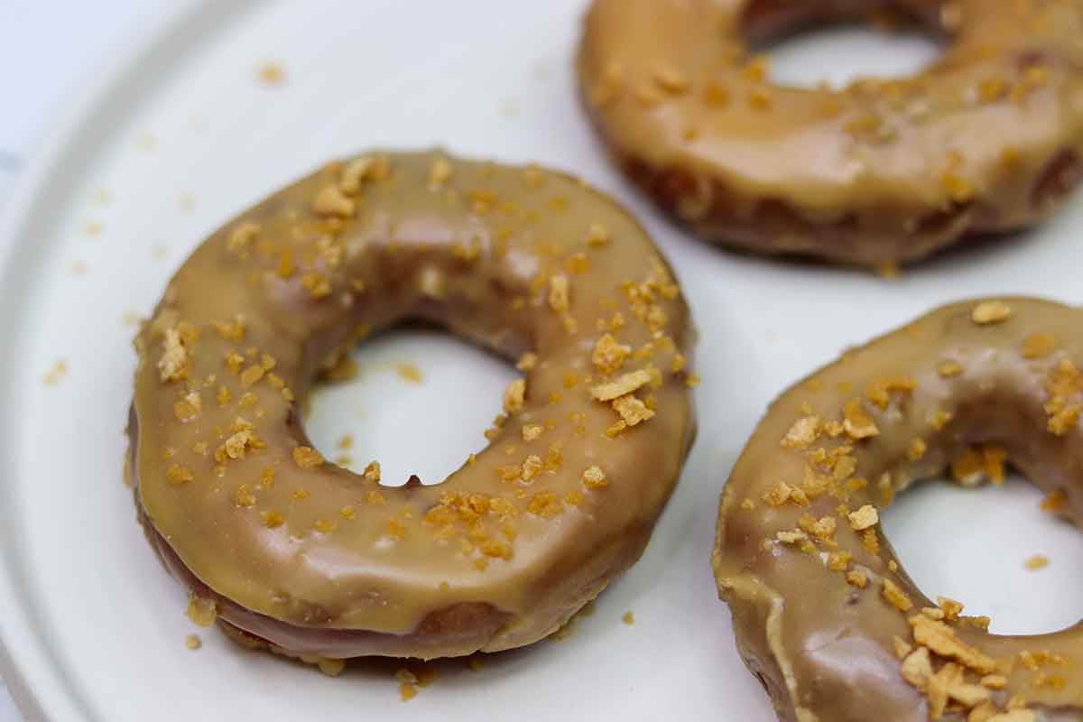 Three glazed doughnuts on a plate