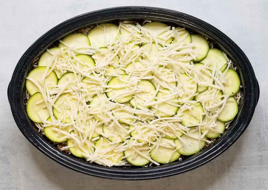 Thin layer of dairy free cheese across last zucchini top layer