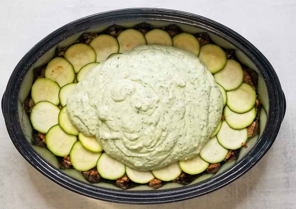 Cheese and egg sauce on top of meat and zucchini layers