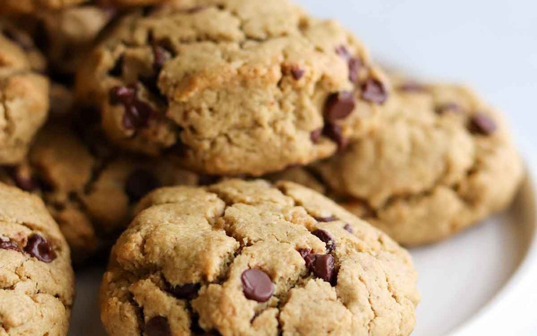 Chocolate chip cookies piled high on a white plate