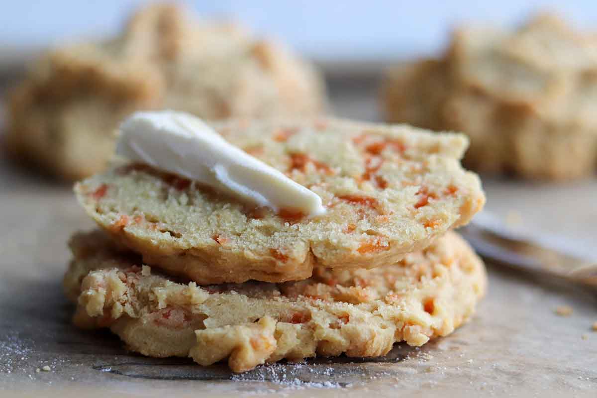 Cut open dairy free cheese biscuits with dairy free butter ontop