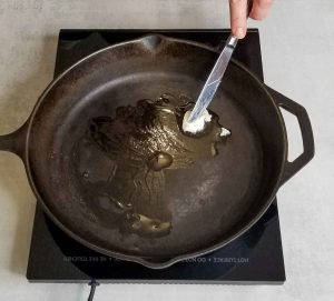 Heated cast iron pan with melting beef tallow