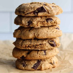 Tiger nut chocolate chip cookies stacked on top of each other and placed on top of parchment papers