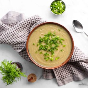 overhead view of cauliflower soup with fresh herbs sprinkled on top