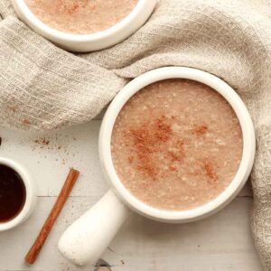 Overhead view of buckwheat porridge in a white ceramic disk surrounded by cream coloured kitchen clothes