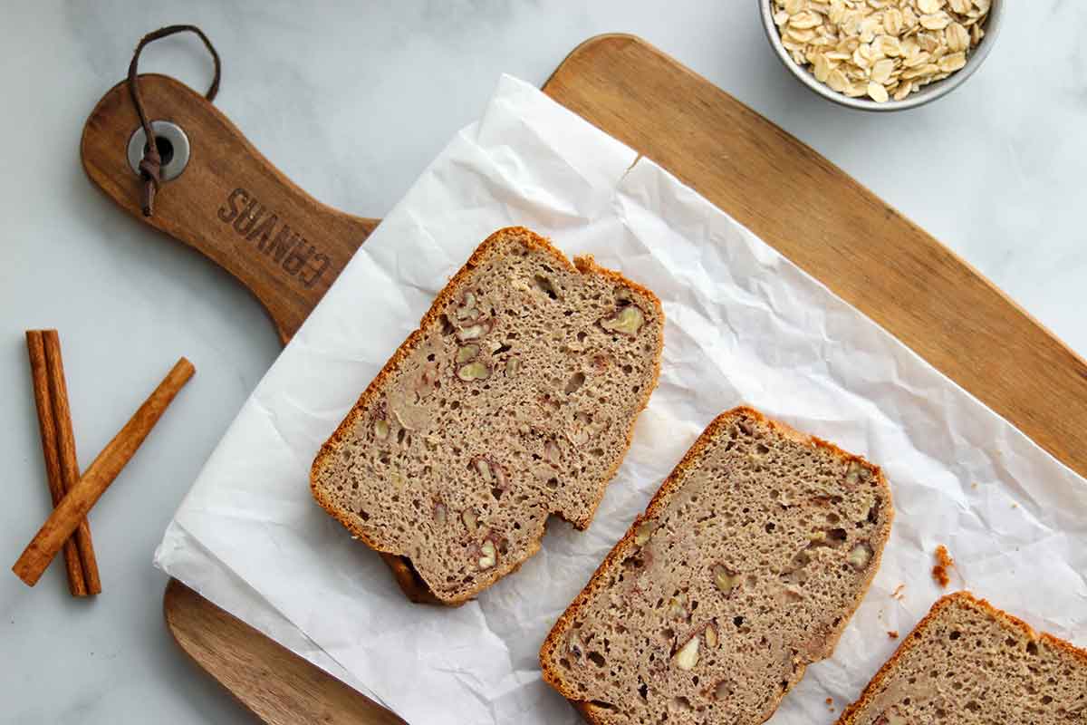 Oat flour banana bread slices placed on a wooden serving board covered with parchment paper