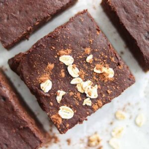 Close up overhead view of oat flour brownies sprinkled with cocoa and dry oats