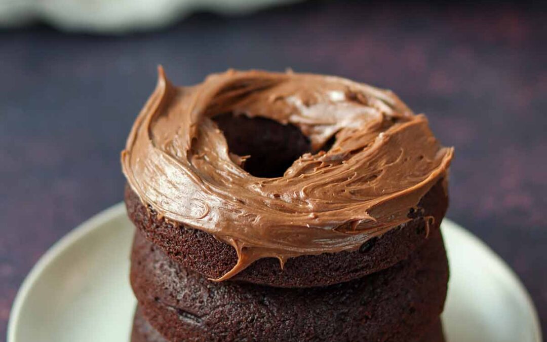 Stacked chocolate cassava flour donuts with chocolate icing.