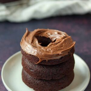 Stacked chocolate cassava flour donuts with chocolate icing.